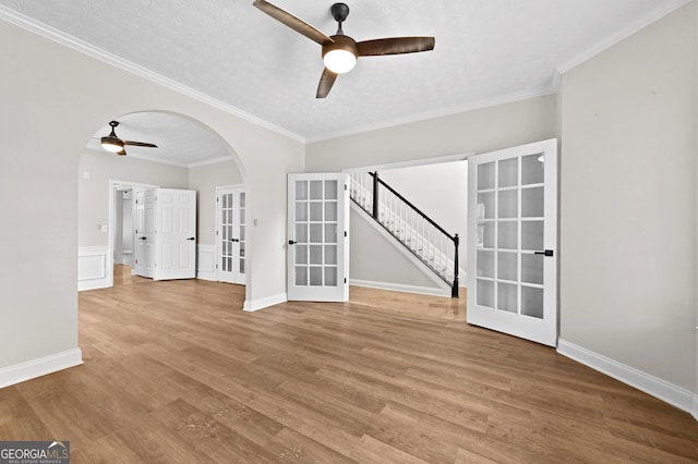 unfurnished room featuring ornamental molding, hardwood / wood-style floors, ceiling fan, and french doors