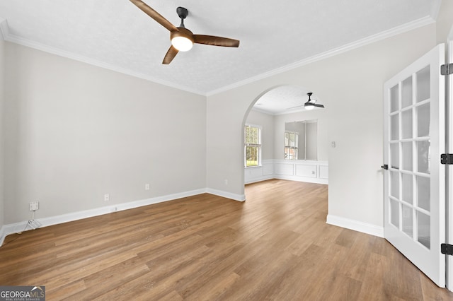 empty room featuring ceiling fan, ornamental molding, and light hardwood / wood-style flooring