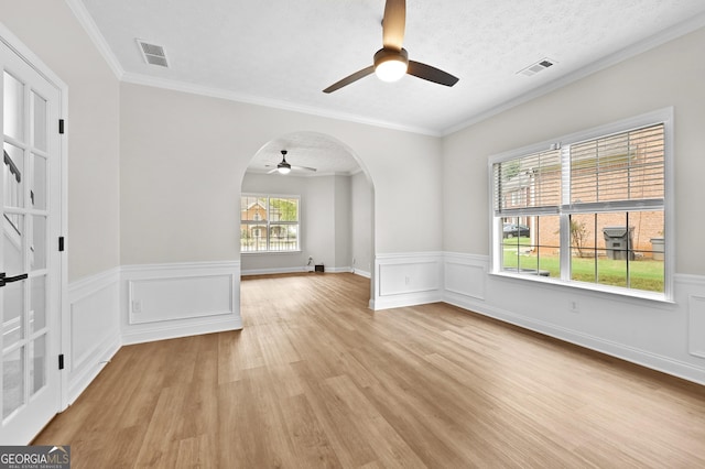 spare room featuring crown molding, a textured ceiling, light hardwood / wood-style flooring, and ceiling fan