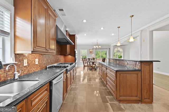 kitchen featuring pendant lighting, tasteful backsplash, sink, dark stone countertops, and stainless steel appliances