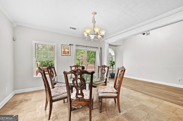 dining room featuring an inviting chandelier, ornamental molding, and a textured ceiling