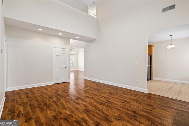 interior space with hardwood / wood-style flooring and a high ceiling