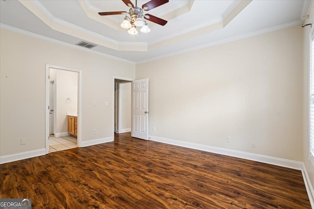 unfurnished bedroom with ornamental molding, ensuite bathroom, light hardwood / wood-style floors, and a tray ceiling