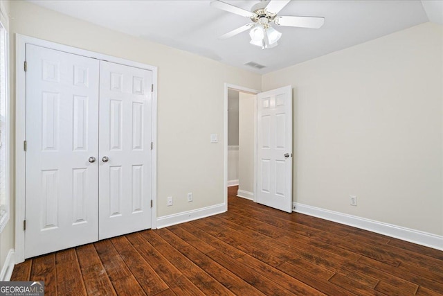 unfurnished bedroom with a closet, dark hardwood / wood-style floors, and ceiling fan