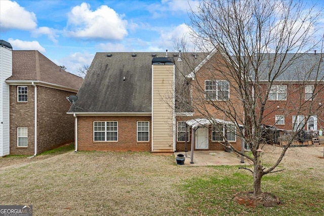 rear view of property featuring a patio and a lawn