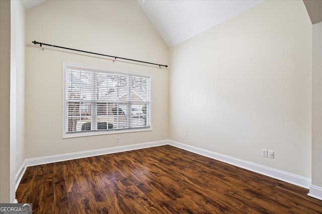 spare room with dark hardwood / wood-style flooring and vaulted ceiling