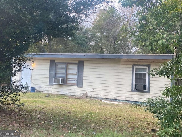 view of home's exterior featuring cooling unit and a lawn