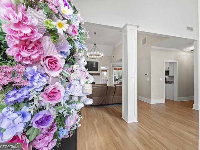 interior space featuring baseboards, light wood-style flooring, visible vents, and a notable chandelier