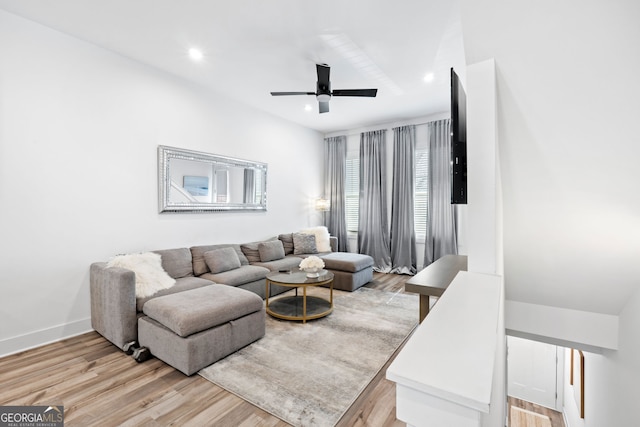 living area featuring baseboards, light wood-type flooring, a ceiling fan, and recessed lighting