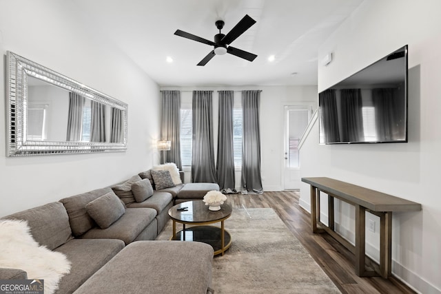 living room with dark wood-type flooring and ceiling fan