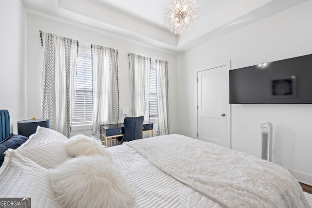 bedroom with a raised ceiling and a notable chandelier