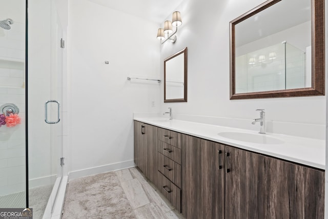 full bath featuring double vanity, a shower stall, baseboards, and a sink