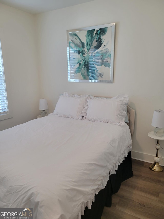 bedroom with wood finished floors and baseboards