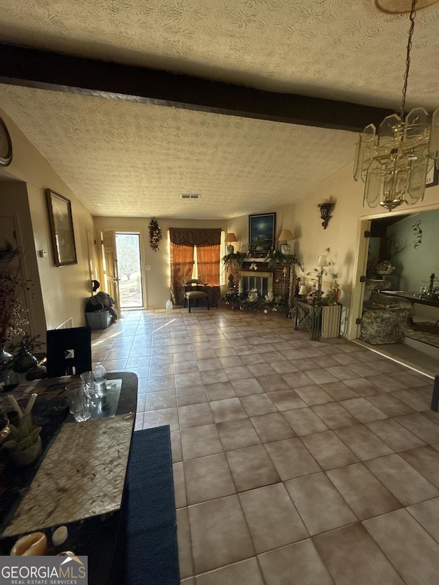 tiled living room with vaulted ceiling with beams, a textured ceiling, and an inviting chandelier