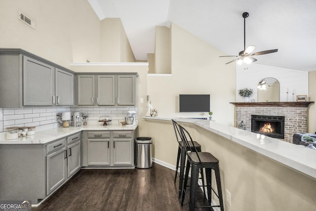 kitchen with gray cabinets, light stone countertops, dark wood-type flooring, and ceiling fan