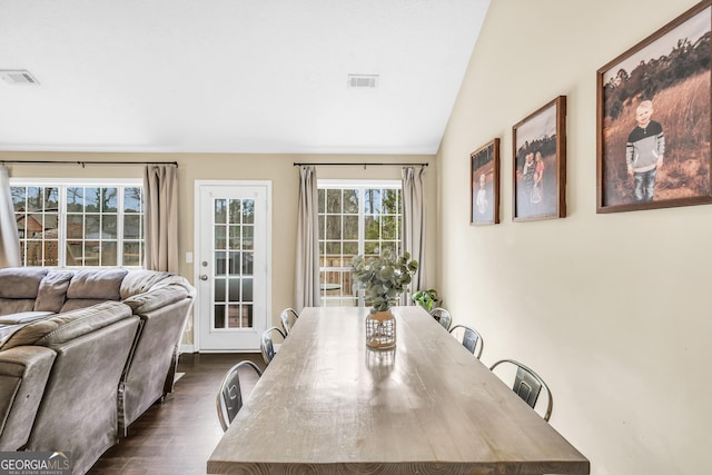 dining room featuring lofted ceiling and dark hardwood / wood-style flooring