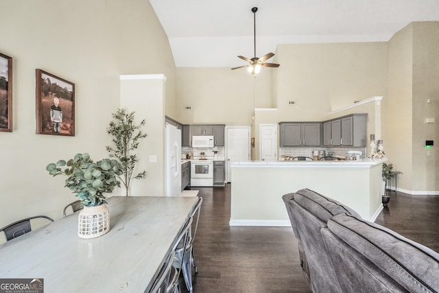 kitchen featuring tasteful backsplash, white appliances, dark hardwood / wood-style floors, and gray cabinetry