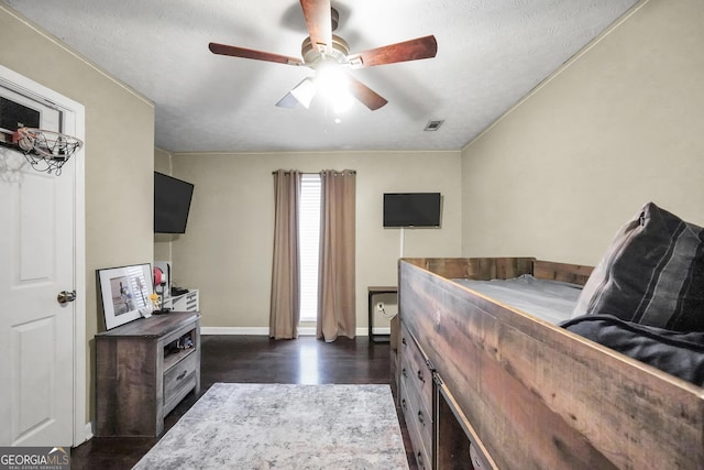 bedroom with ceiling fan, dark hardwood / wood-style flooring, and a textured ceiling