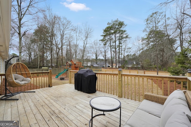 wooden deck with area for grilling, an outdoor living space, and a playground