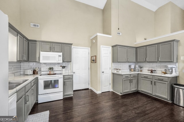 kitchen with white appliances, dark hardwood / wood-style floors, and gray cabinetry