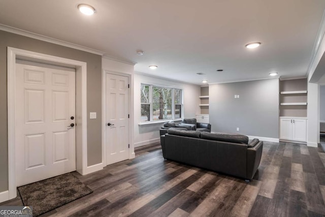 living room with crown molding, dark hardwood / wood-style flooring, and built in shelves