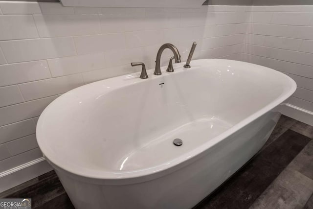 bathroom with tile walls and a bathtub