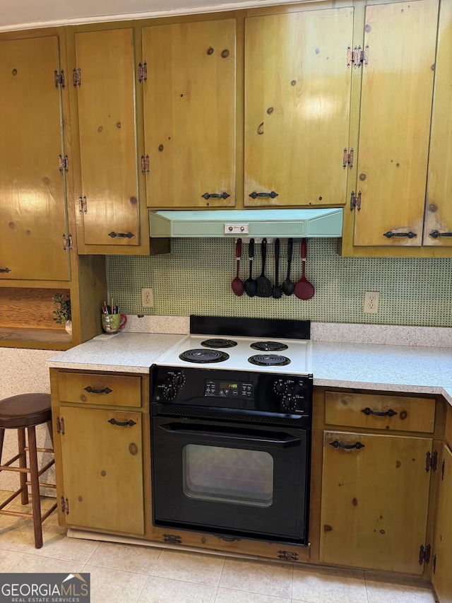 kitchen featuring black / electric stove and a breakfast bar