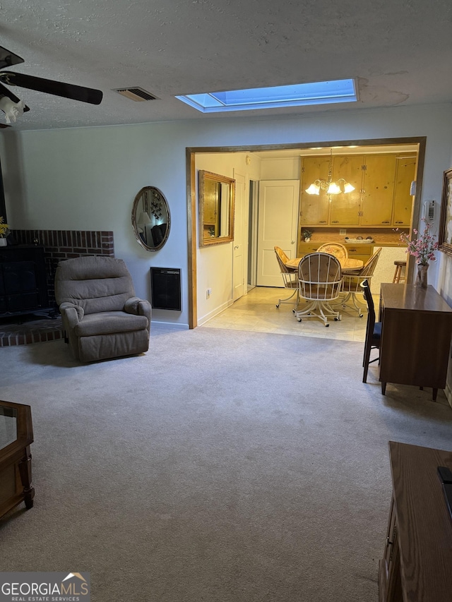 carpeted living room featuring a textured ceiling and a skylight