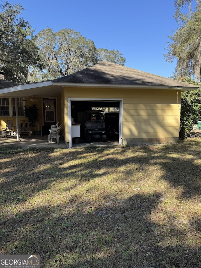 rear view of house with a garage and a lawn