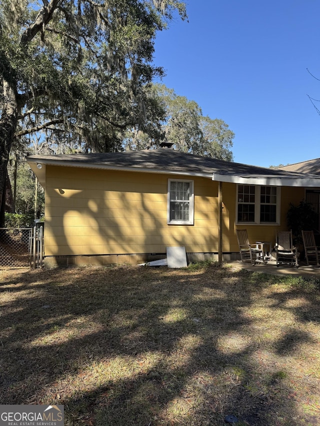 rear view of house with a yard and a patio