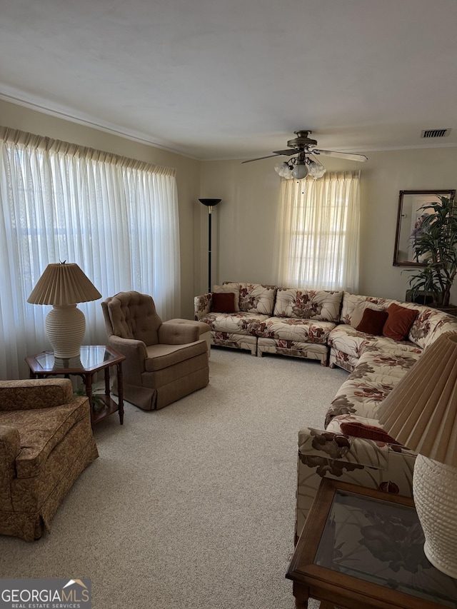 living room featuring ornamental molding, carpet flooring, and ceiling fan