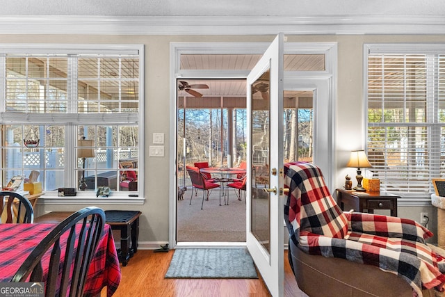 doorway featuring crown molding, light hardwood / wood-style floors, french doors, and a textured ceiling