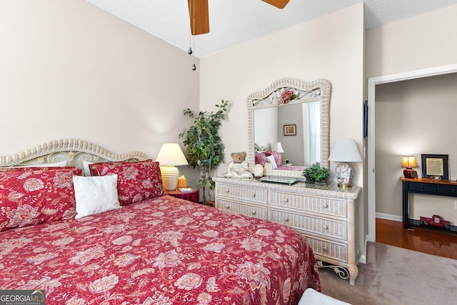 bedroom with ceiling fan, lofted ceiling, and a textured ceiling