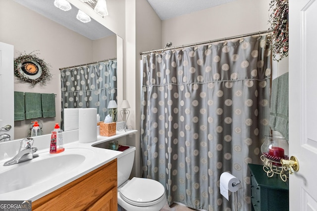 bathroom featuring vanity, a textured ceiling, and toilet