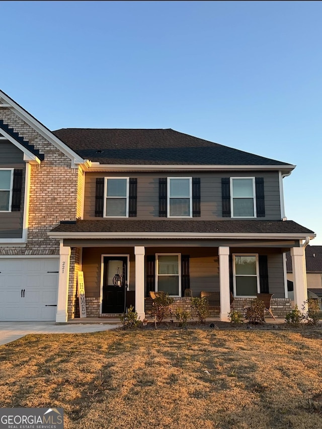 view of front facade with a garage, a front yard, and covered porch