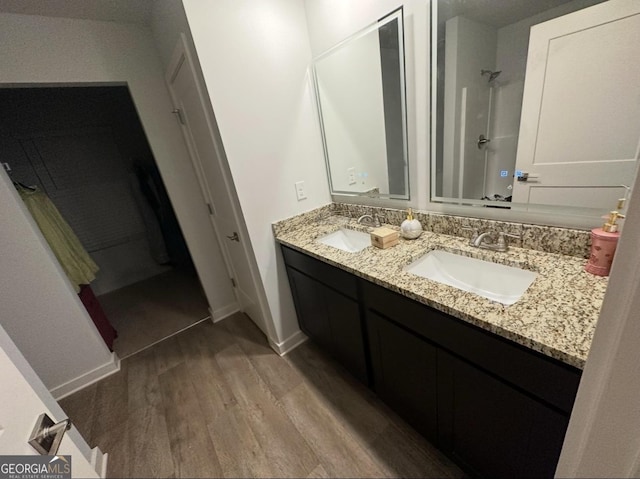 bathroom featuring hardwood / wood-style flooring, vanity, and a shower