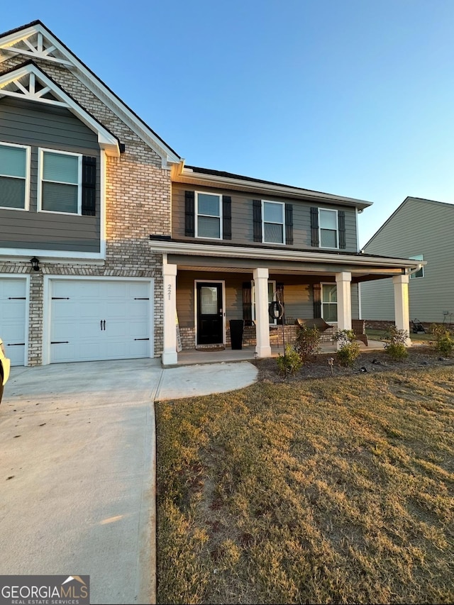 view of front of property featuring a garage, a front lawn, and a porch