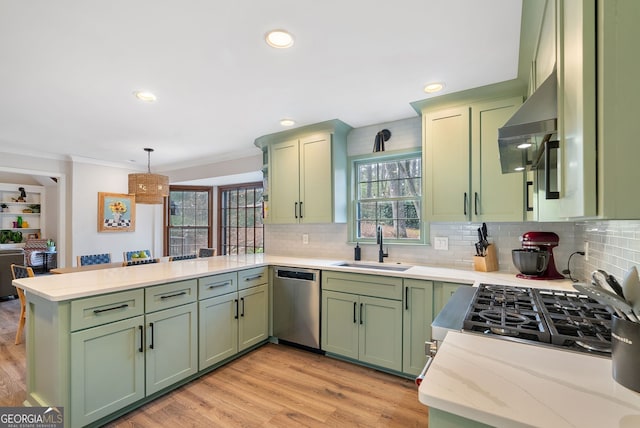 kitchen featuring kitchen peninsula, decorative light fixtures, green cabinetry, and dishwasher