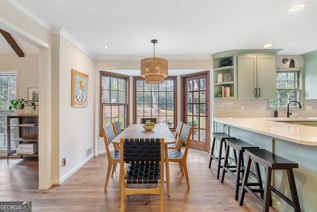 dining area with plenty of natural light, sink, and light hardwood / wood-style floors