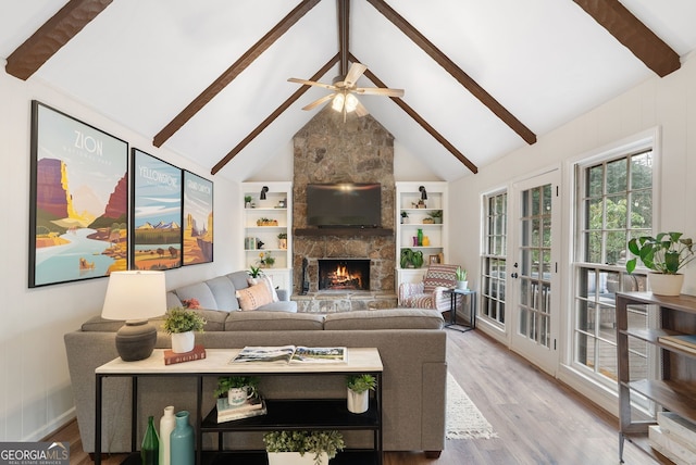 living room with beamed ceiling, high vaulted ceiling, a fireplace, and light wood-type flooring