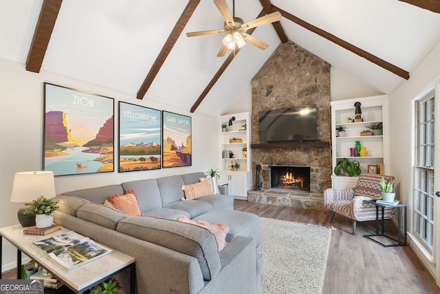 living room with a stone fireplace, high vaulted ceiling, wood-type flooring, ceiling fan, and beam ceiling