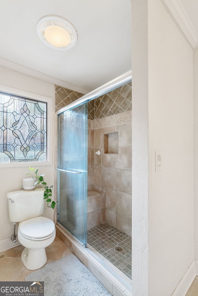 bathroom with tile patterned flooring, ornamental molding, a shower with door, and toilet