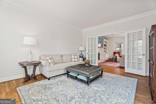 living room featuring hardwood / wood-style flooring, crown molding, and french doors