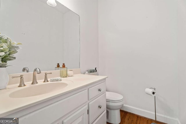 bathroom featuring vanity, hardwood / wood-style flooring, and toilet