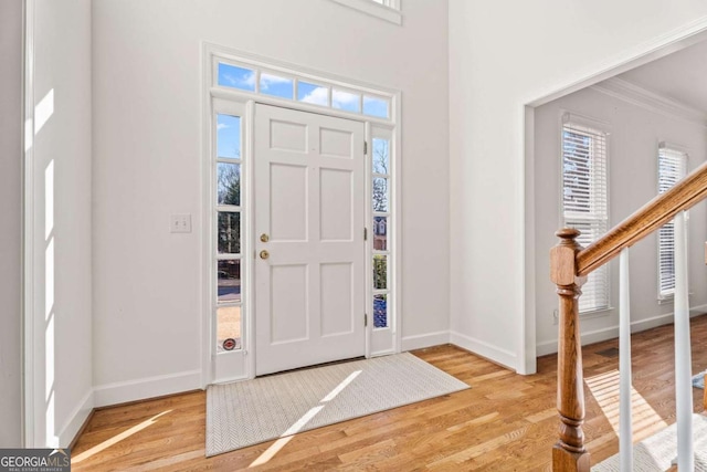 entryway featuring ornamental molding and light hardwood / wood-style floors