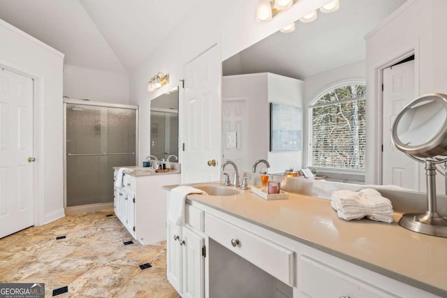 bathroom with vanity, vaulted ceiling, and a shower with shower door