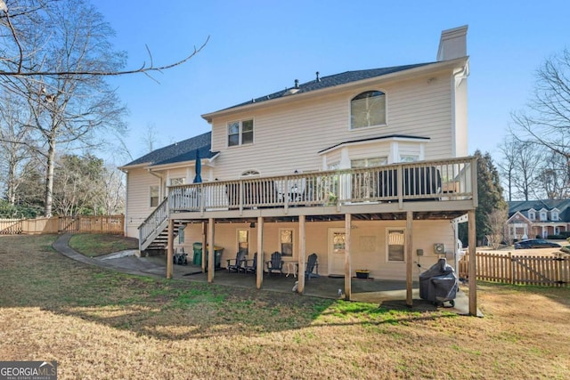 back of property with a lawn and a deck