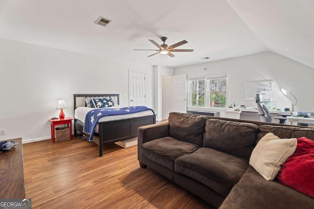 bedroom with hardwood / wood-style flooring, vaulted ceiling, and ceiling fan