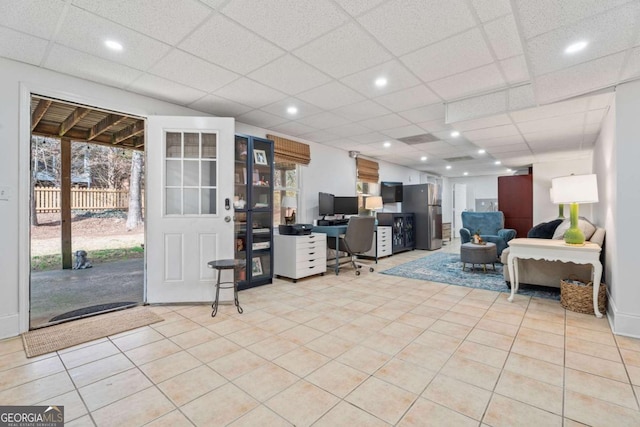 living room with light tile patterned floors and a drop ceiling