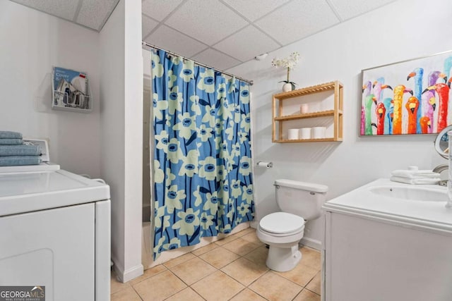 full bathroom featuring toilet, vanity, washer / clothes dryer, tile patterned flooring, and a drop ceiling